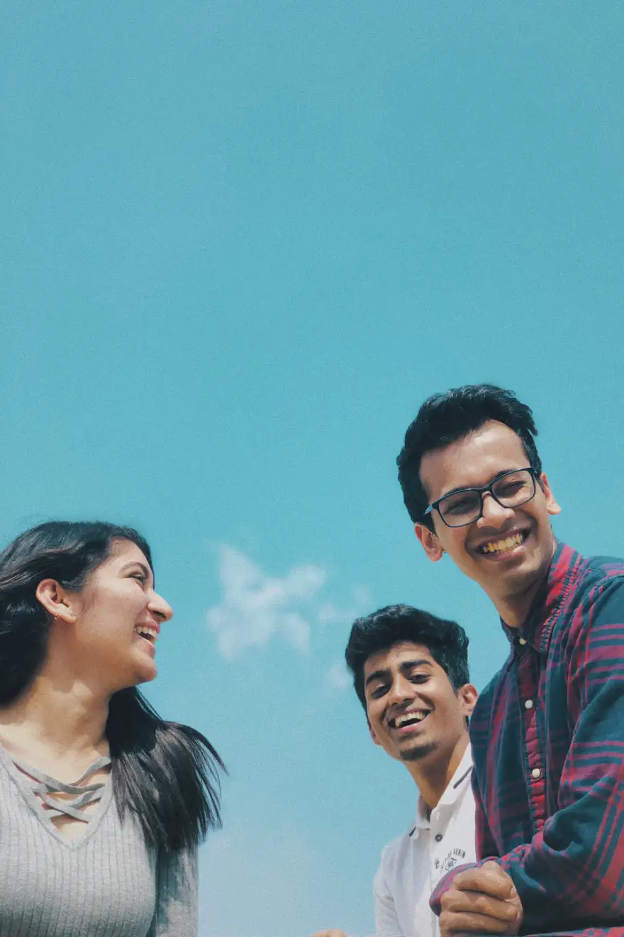 Three students laughing together outdoors
